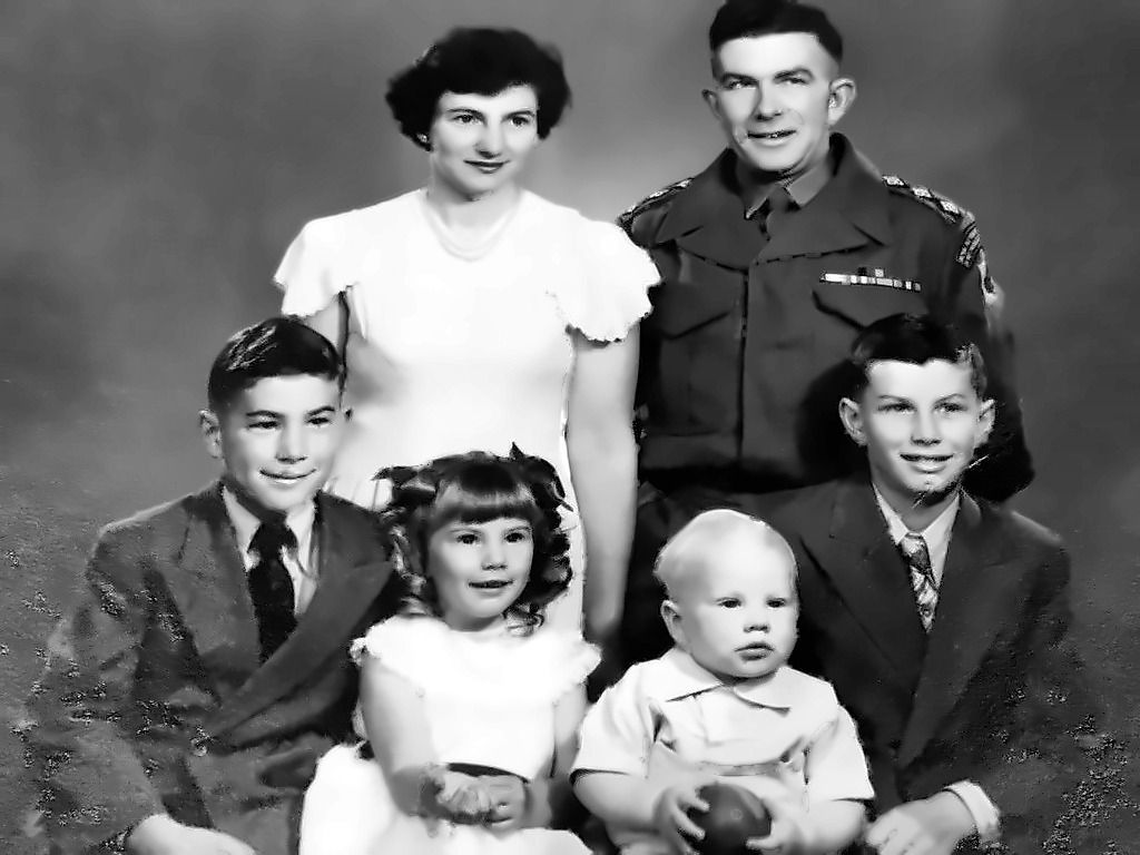 The same family portrait restored in black and white: scratches and dust removed, contrast brought back